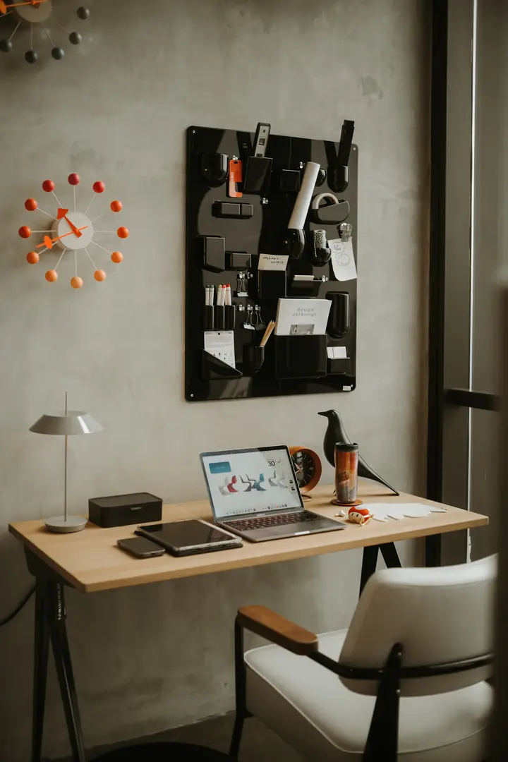 A tidy desk with a laptop, a green lamp and purple notebooks